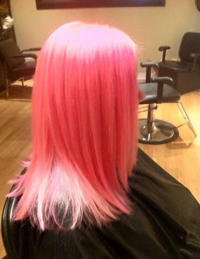 Shoulder-length straight bright-pink hair fading to pale pink ends, seen from behind.